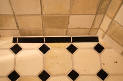 Visby Beikes Keramisk Interiør - badeværelse med håndlavede stentøjsbrændte fliser på gulv og i bruseniche. Fliserne er tilpasset det linjeafløb, vi har anlagt i brusenichen.
