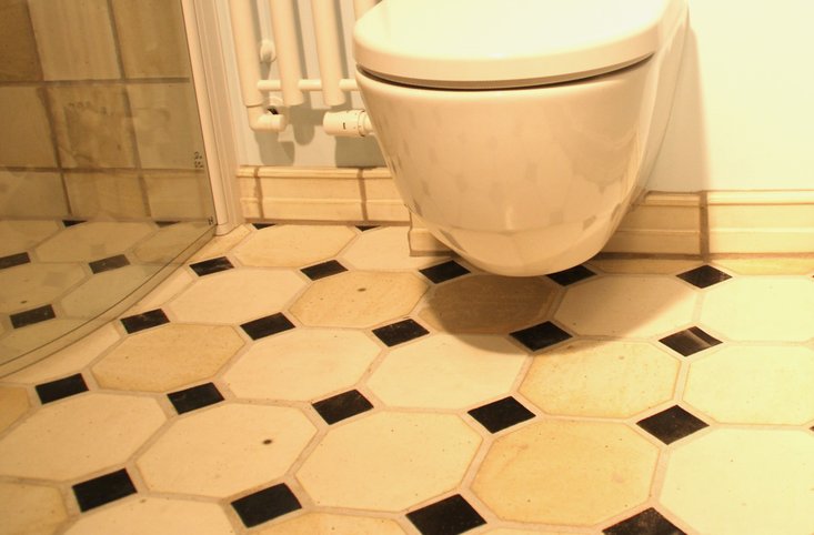 Visby Beikes Keramisk Interiør - badeværelse med håndlavede stentøjsbrændte fliser på gulv og i bruseniche. 